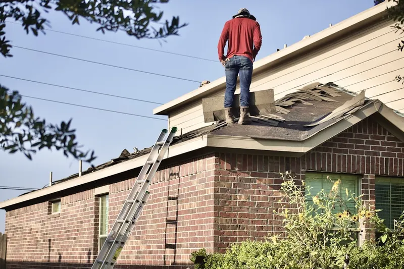 Professional roofer working on a residential roof in Faye Wright